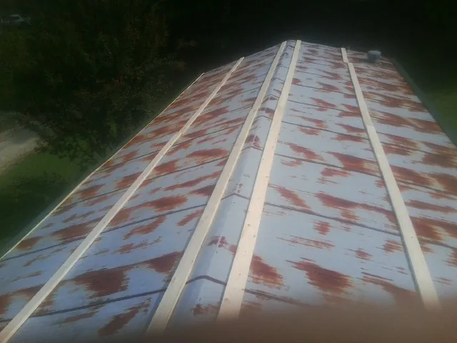 Rusted metal roof panels with new wood purlins before replacement — Storm Damage Roof Repair in Ashaway by Roofing Brothers
