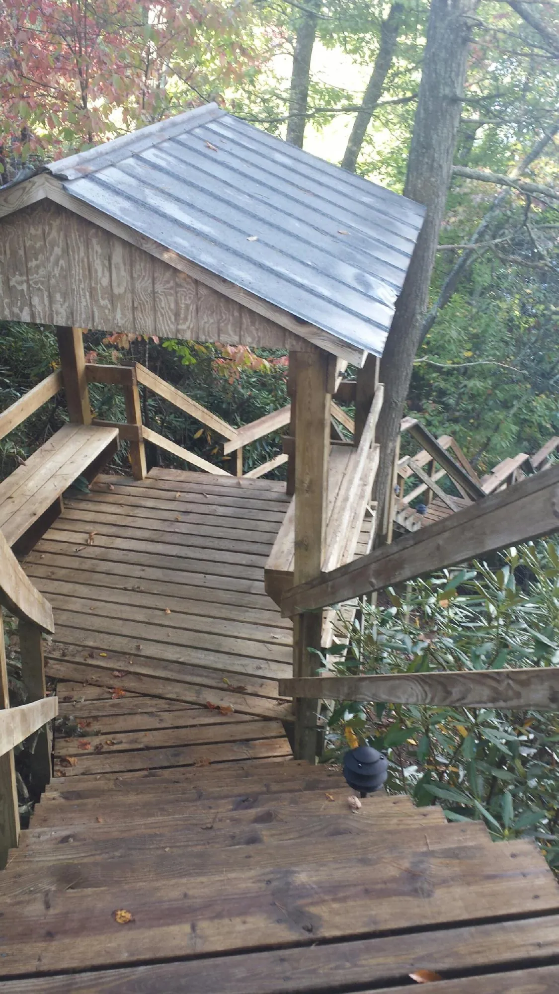 Metal roofed shelter over wooden steps on a wooded walkway — Skylight Repair & Installation work by our crew in Ashaway