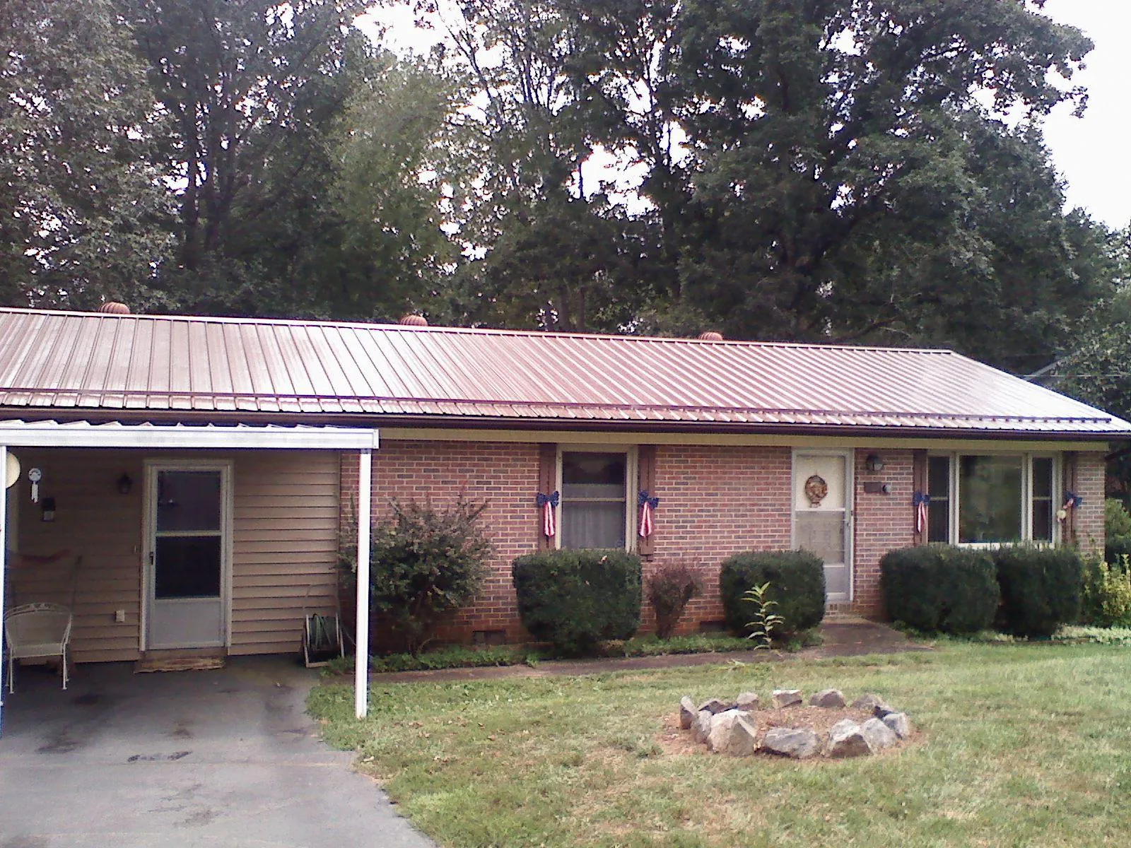 Bronze metal roof and carport on a brick ranch home — Roof Repair work by our crew in Ashaway